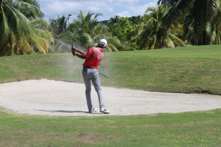 Alex Kangoo digs himself out of the bunker at the 15th hole