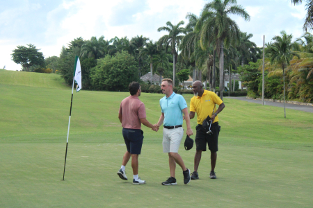 Andrew Arft (Back turned), Josh Anderson (centre) and Chris Richards shake hands after all three Birdied on the 18th hole at Tryall